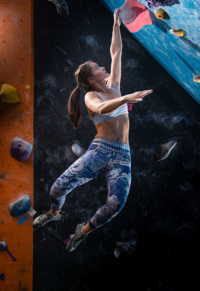 Female bouldering climber hanging